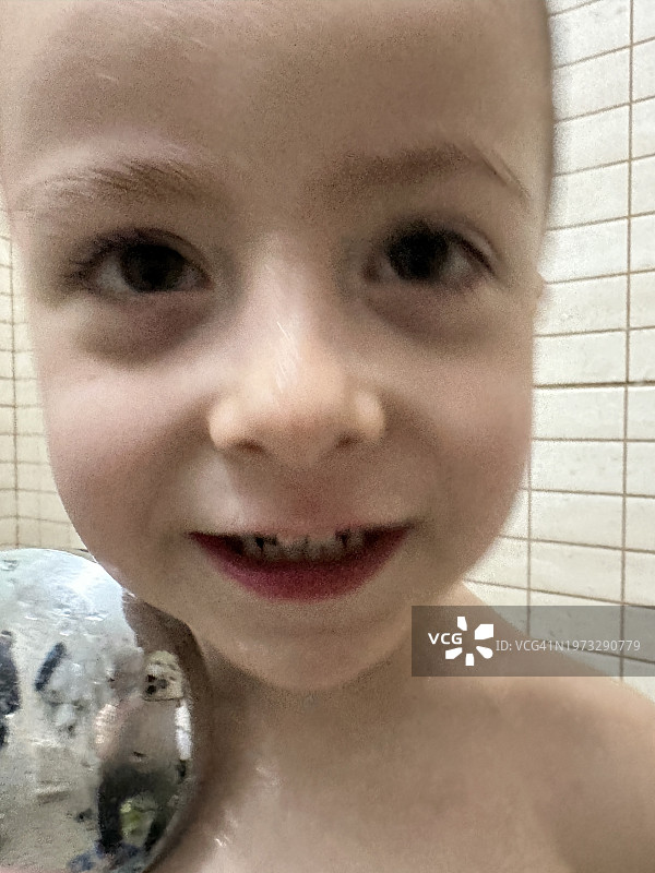 淋浴后在浴室里洗脸和玩水的三岁男孩图片素材
