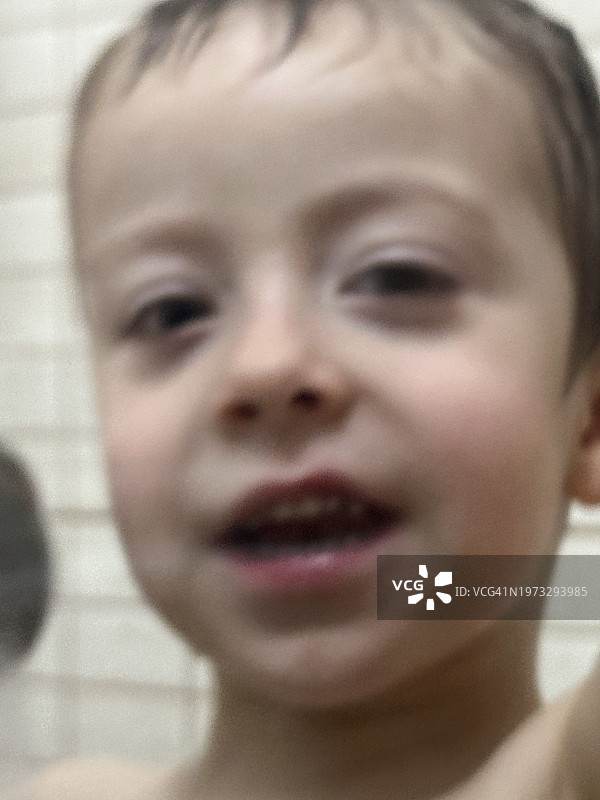 淋浴后在浴室里洗脸和玩水的三岁男孩图片素材