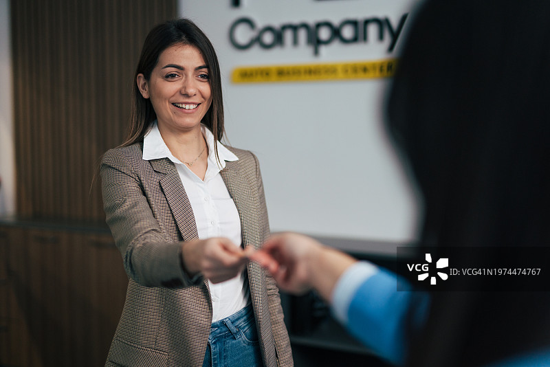 一位女士将信用卡递给行政人员图片素材