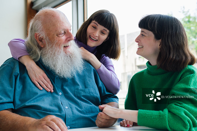 祖父在咖啡馆与两个孙女共度时光图片素材