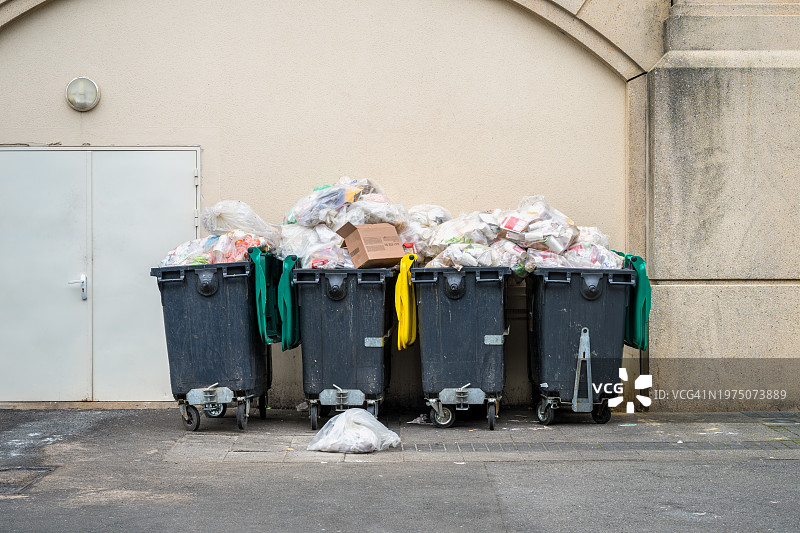 购物中心外小巷里装满垃圾的垃圾桶图片素材