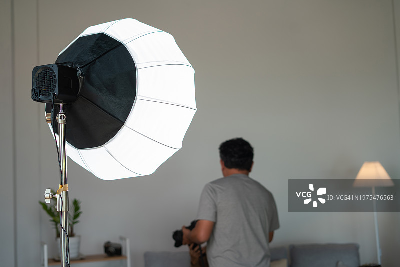 摄影师在工作室的灯光下拍摄背面图片素材