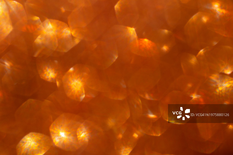 抽象的橙色全息背景与闪耀的散景，可用作叠加层图片素材