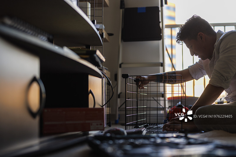 制作家具：西班牙裔工人在公寓安装网格架图片素材