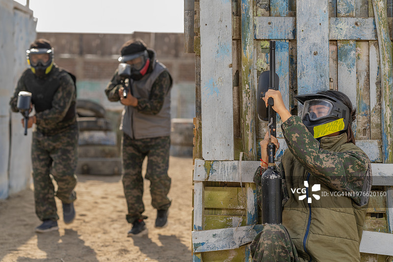 准备射击的朋友们一起玩彩弹射击的女人图片素材
