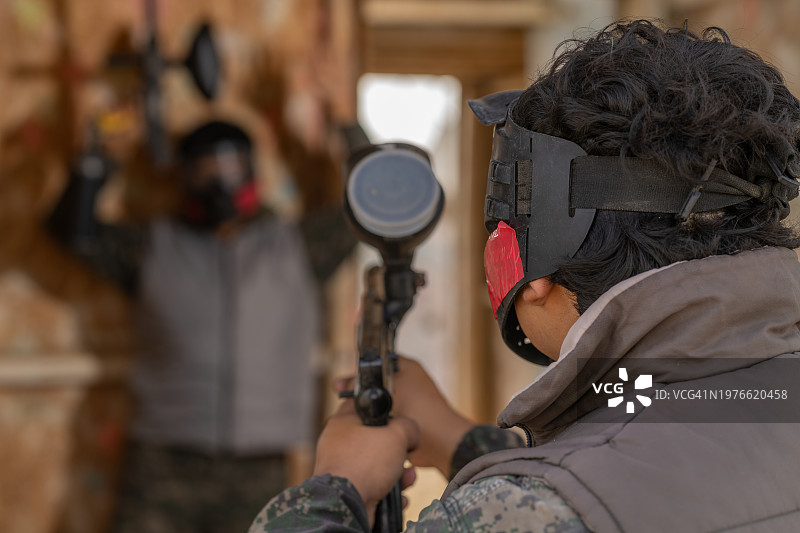 男人向玩彩弹的朋友射击图片素材