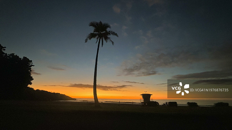 夏威夷大岛哈普纳海滩棕榈树与救生员棚屋日落剪影图片素材