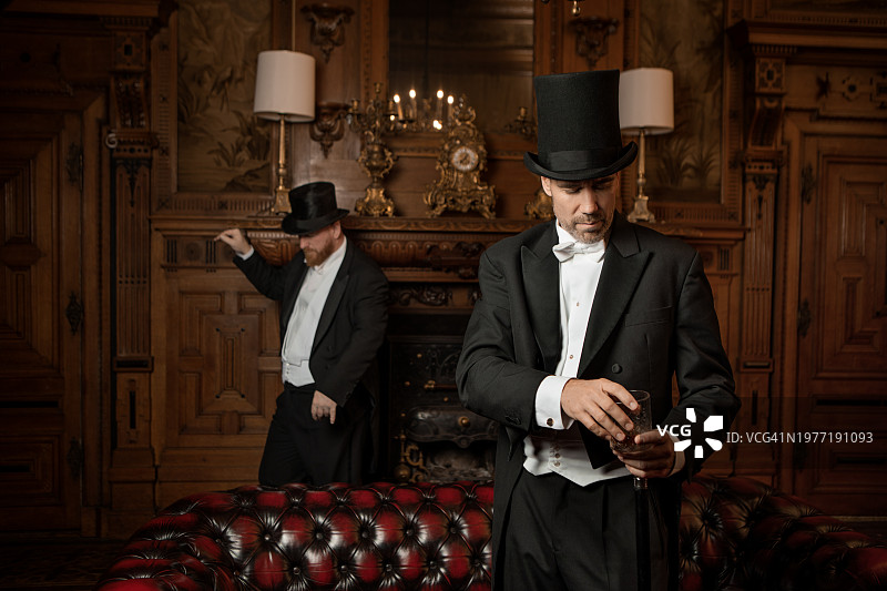 两名英俊优雅的1920年代风格绅士在豪华的豪宅中图片素材