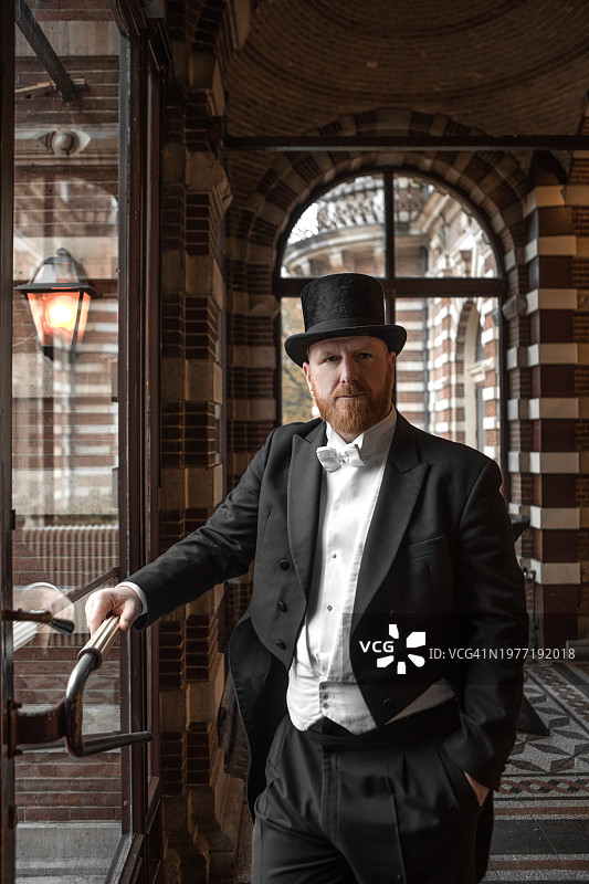 身穿豪华住宅的英俊优雅的1920年代风格绅士图片素材