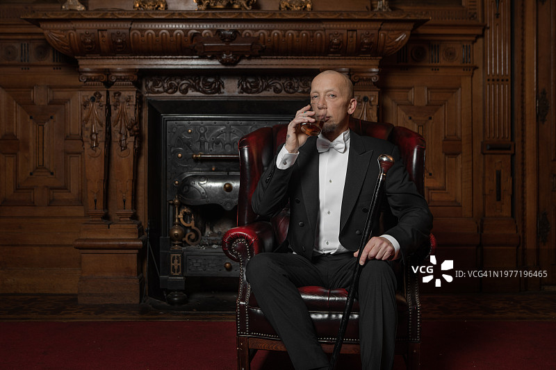 身穿豪华住宅的英俊优雅的1920年代风格绅士图片素材