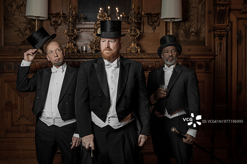 客厅里三个穿着1920年代风格的英俊男士图片素材
