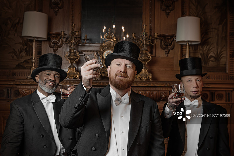 客厅里三个穿着1920年代风格的英俊男士图片素材