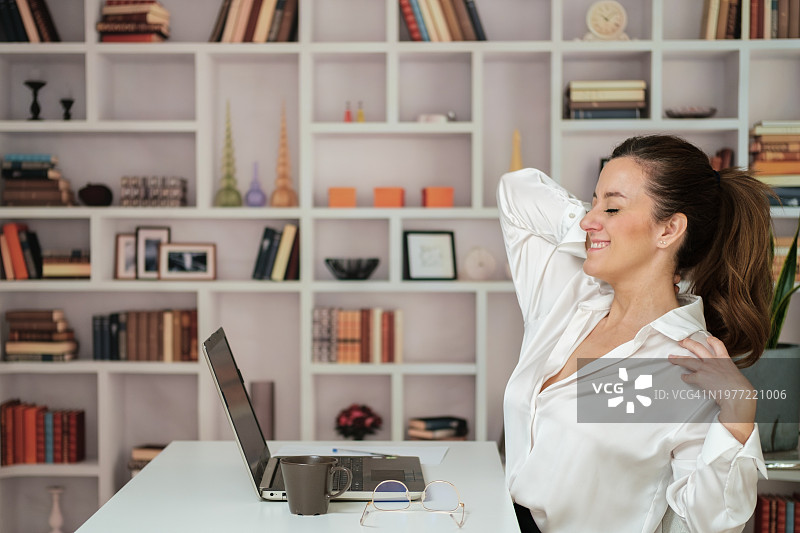 工作结束后在办公室放松伸展身体的女人，感到舒适图片素材