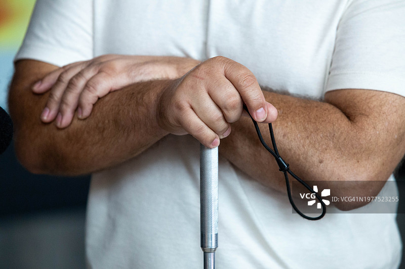 手臂交叉，拄着白色手杖的视力障碍（盲人）图片素材