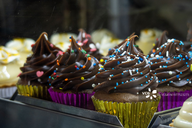 装满彩色纸杯蛋糕的展示托盘图片素材