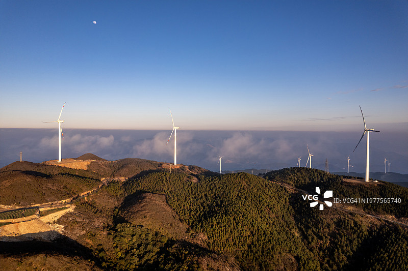 傍晚时分，山上的梯田和风力涡轮机图片素材
