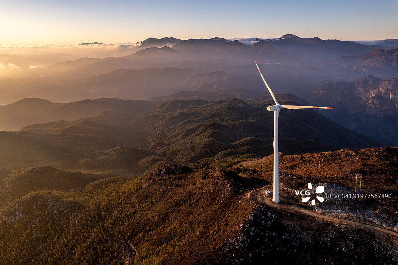 傍晚时分，山上的梯田和风力涡轮机图片素材