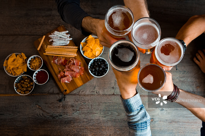 朋友们在酒吧里举杯畅饮啤酒俯视图图片素材
