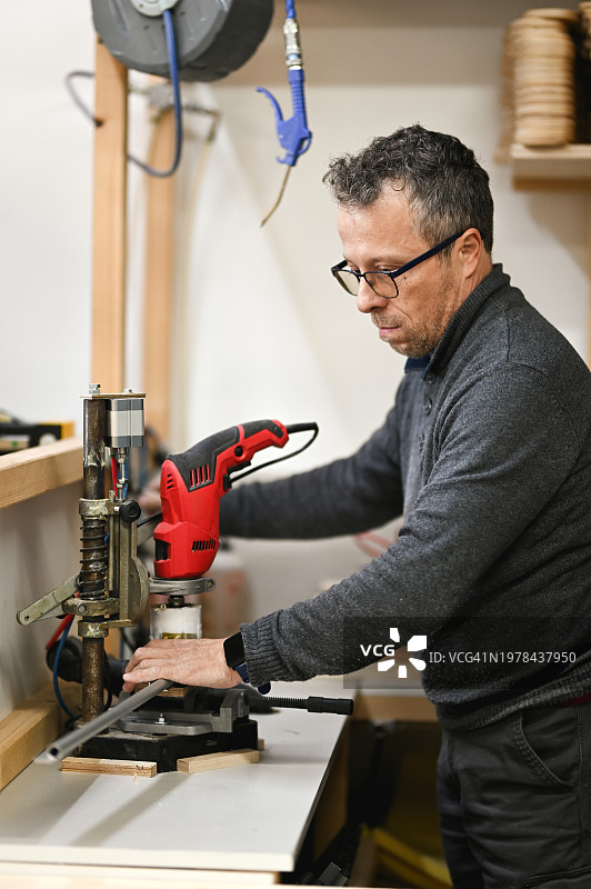 在木workshop使用钻床工作的男人图片素材