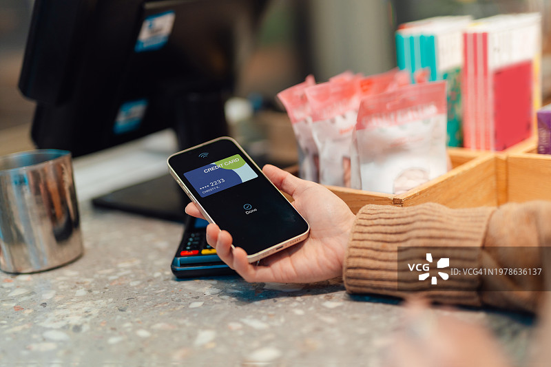 女性用智能手机进行移动支付的特写图片素材