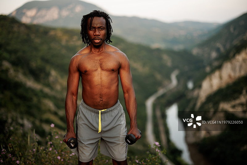 在山举重的年轻非洲男人图片素材