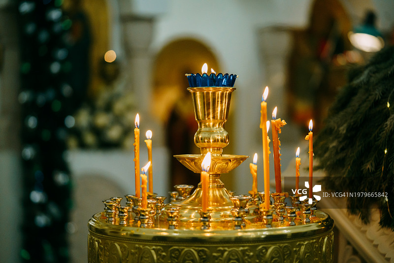 东正教教堂中圣像背景下的燃烧蜡烛图片素材