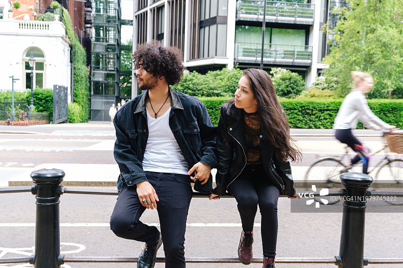 在城市街道栏杆上放松的情侣图片素材