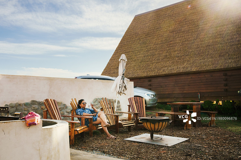 在度假小屋的露台上放松的微笑女人图片素材