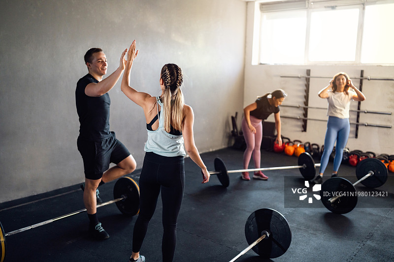 一群人在运动后与交叉训练器击掌图片素材