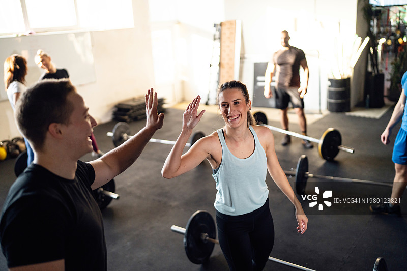 一群人在运动后与交叉训练器击掌图片素材