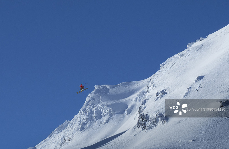 滑雪者在雪坡上跳跃图片素材