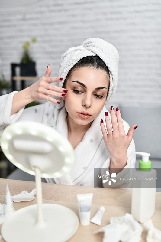 沐浴后美丽的女子进行面部肌肤护理图片素材