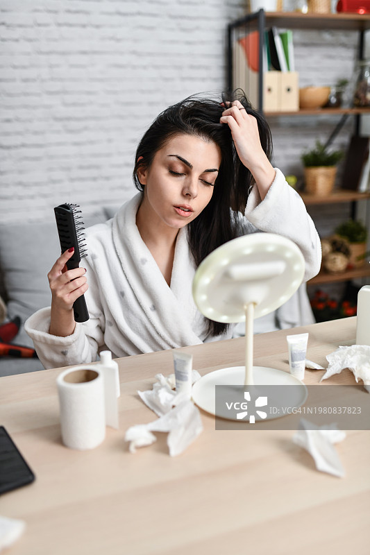 女人梳头时看着镜子里的倒影图片素材