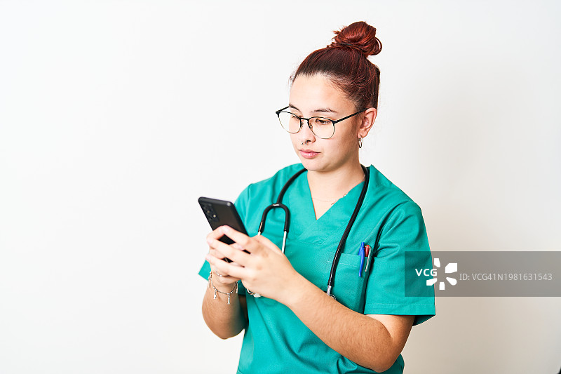 脖子上戴着听诊器、正在使用手机的女人图片素材