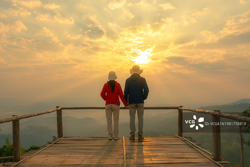 日出时在泰国达府Monmhok Tawan观景点的情侣图片素材