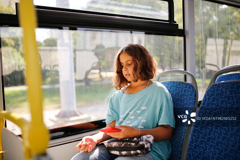 城市探险：青少年使用智能手机乘坐公共交通图片素材