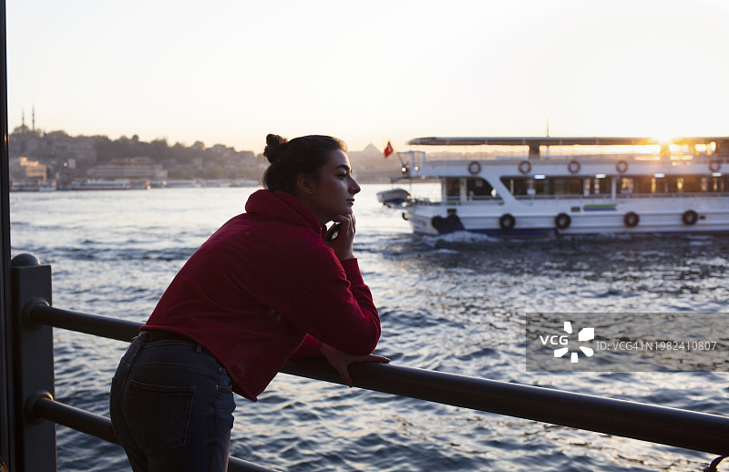 年轻女游客在加拉塔桥欣赏日落美景图片素材