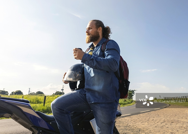 男人和他的摩托车在乡村图片素材