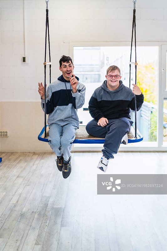 两个残障朋友在秋千上唱歌图片素材