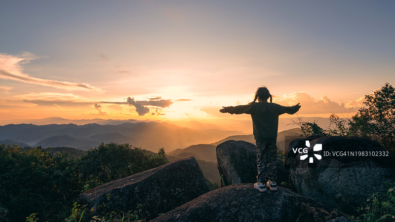 旅行者的女儿在高处欣赏壮丽的日落美景图片素材