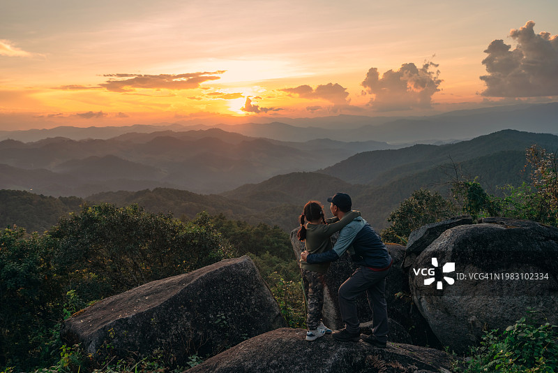 旅行者和家人在高处欣赏壮丽的日落美景图片素材