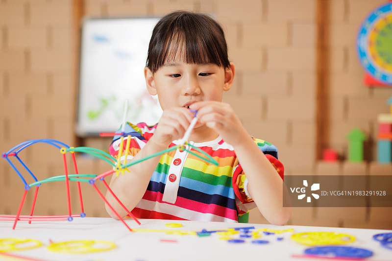 小女孩在家玩拼装玩具图片素材