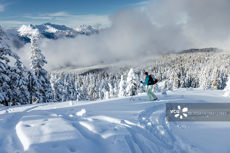 在高山山脊上进行野外滑雪的女人图片素材