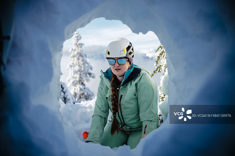 女子在山中雪洞避难所内向外看图片素材