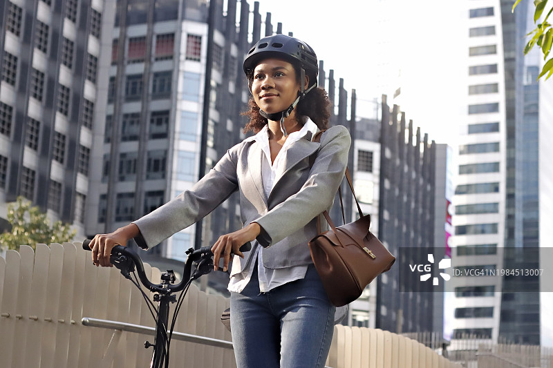 笑容满面的女学生在自行车旁抬头看图片素材