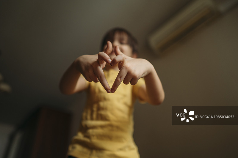 男孩在家用手指比心图片素材