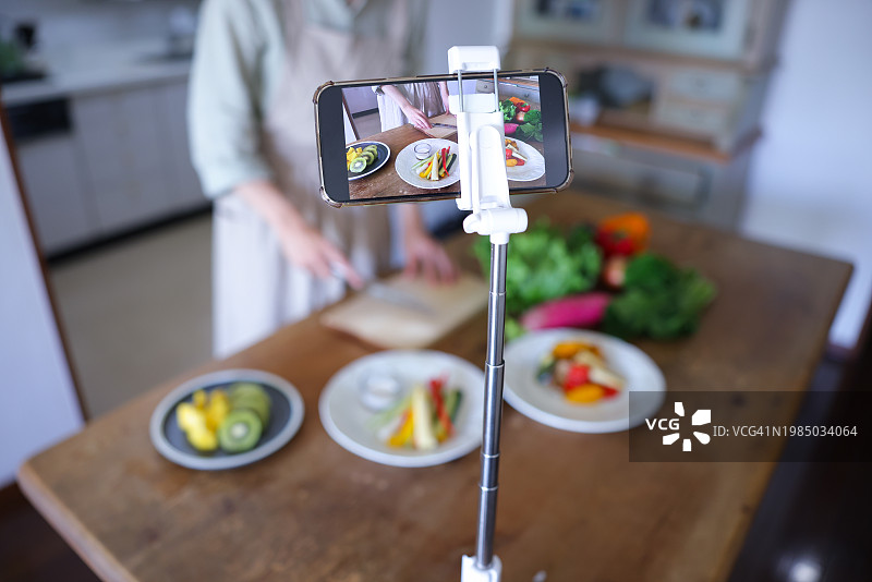 女人在智能手机移动应用程序上制作烹饪课程图片素材