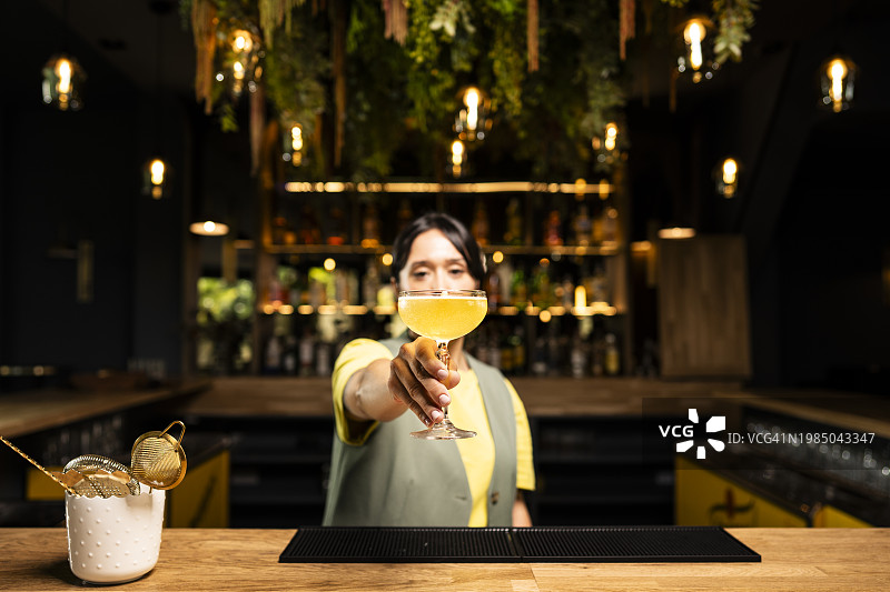 调酒师在酒吧递鸡尾酒杯图片素材