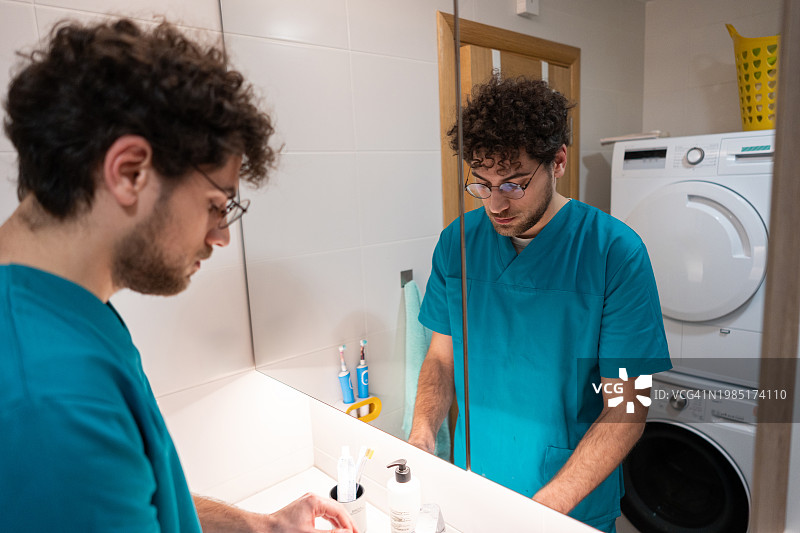 在浴室刷牙的白人男护士图片素材
