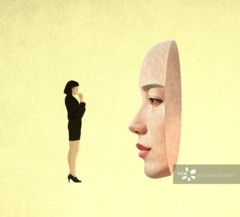 若有所思的女人站在一个超大女性面具前图片素材